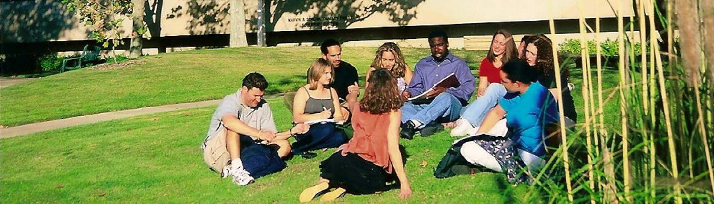 Photograph of students sitting on grass in sculpture garden