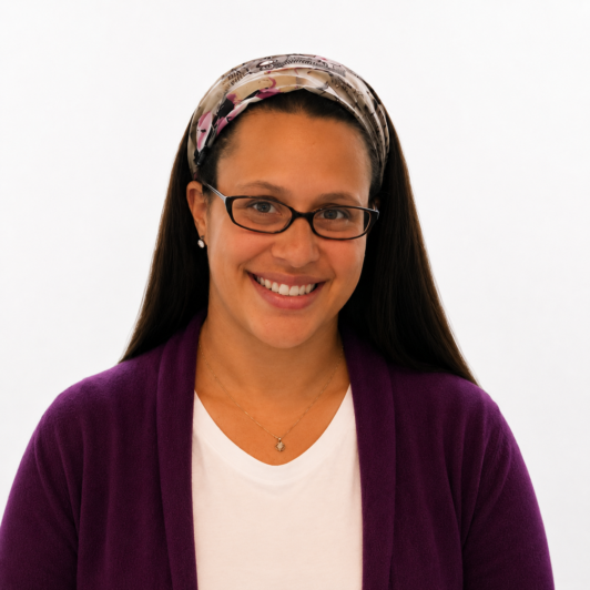 Headshot of Dana Keil in glasses, headband, purple sweater, and white shirt
