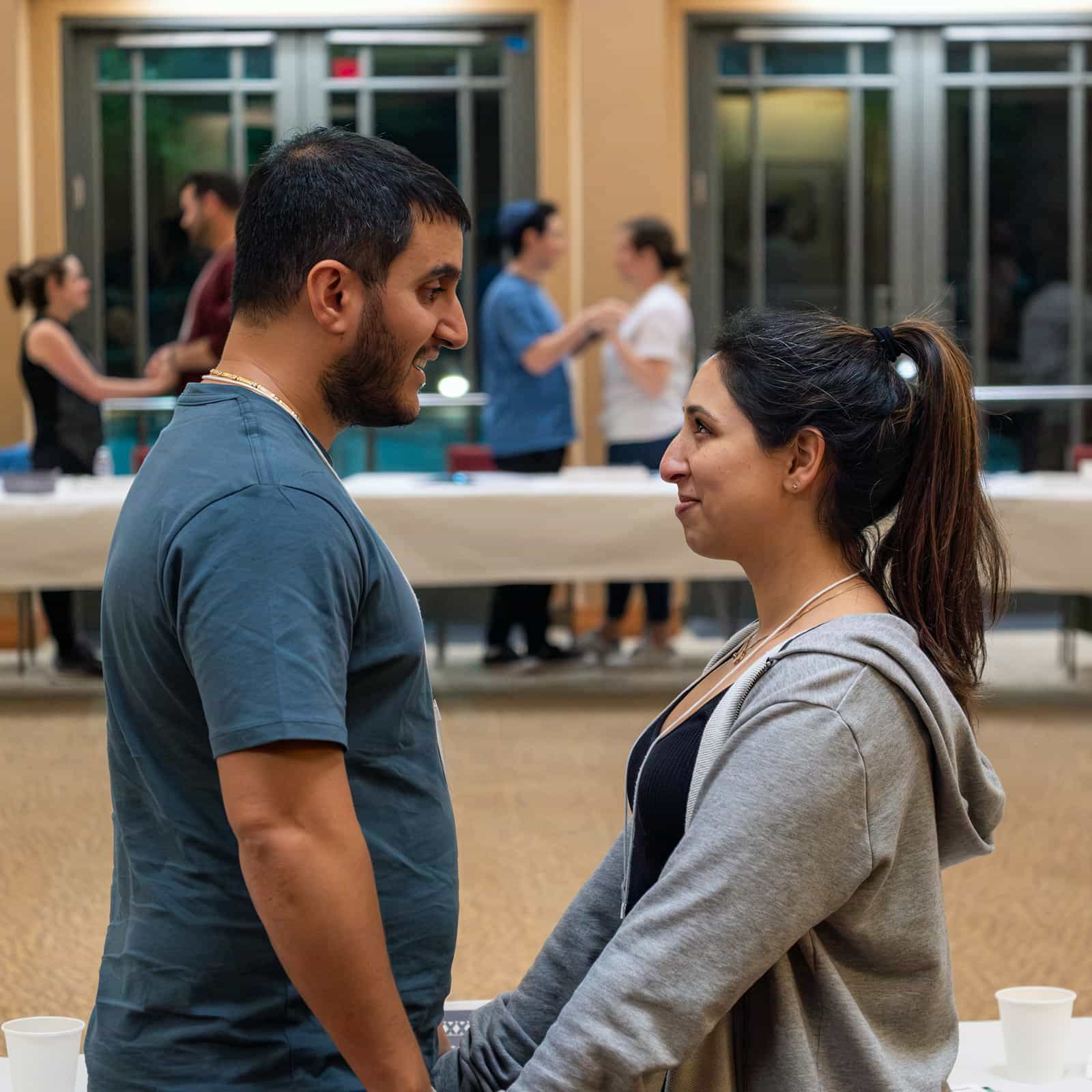 A couple connecting during a Jewish conversion program, standing face to face in a shared learning environment.