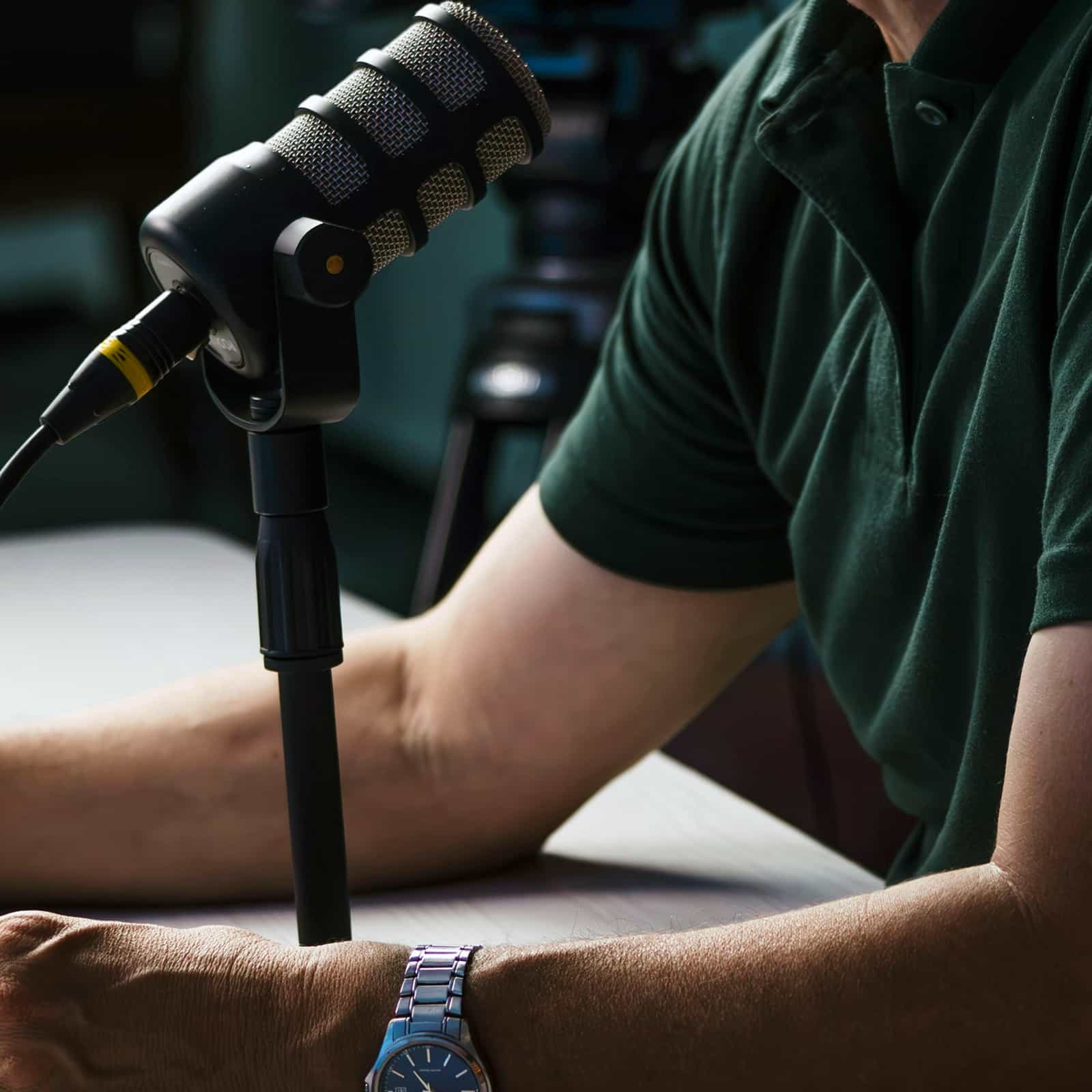 Person speaking into a microphone while recording a podcast for the 2050 Institute.