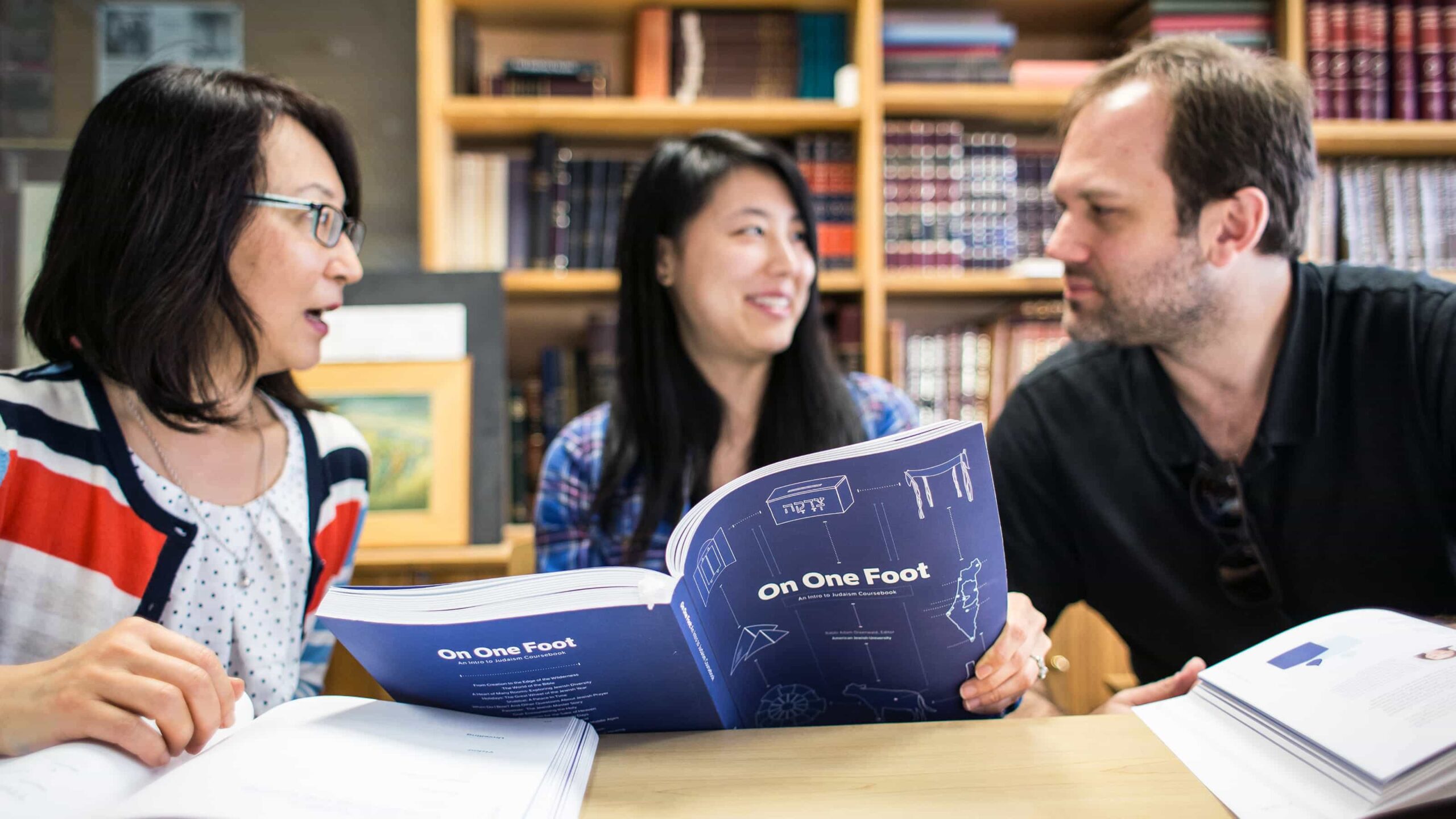 Students discussing and studying together during an introductory Judaism class, reviewing course materials.