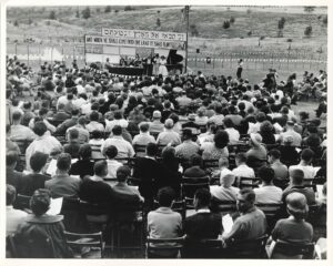 A historic photo of hundreds of people facing a stage at Camp Alonim.