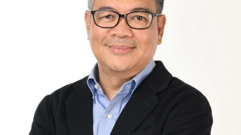 Heatshot of Patrick John Ray Carpio in glasses, a blue shirt, and a black jacket