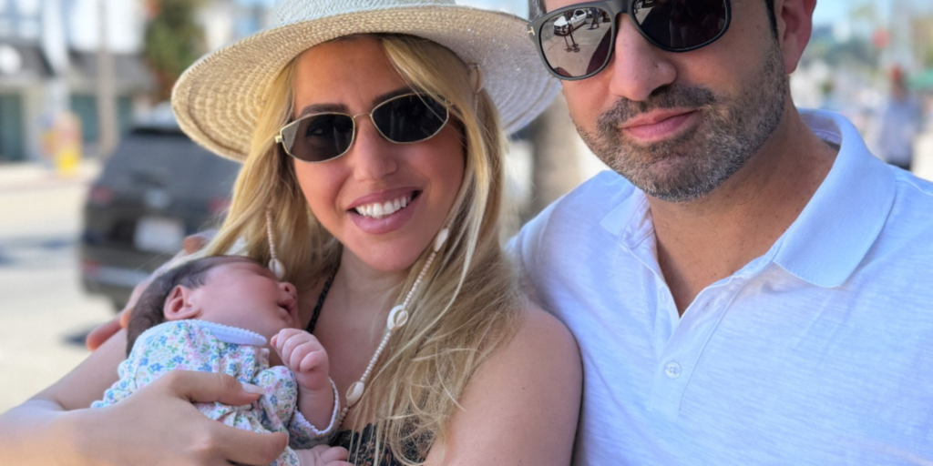 Havva Sevis in a yellow hat with her husband and infant outside in the sunshine