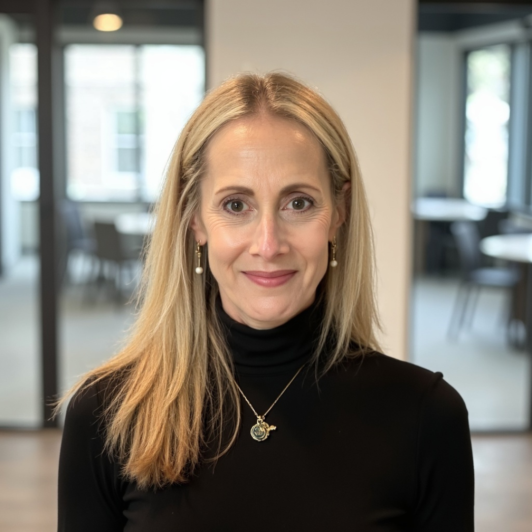 Headshot of Stephanie Slaterin in a black turtle neck sweater and gold necklace