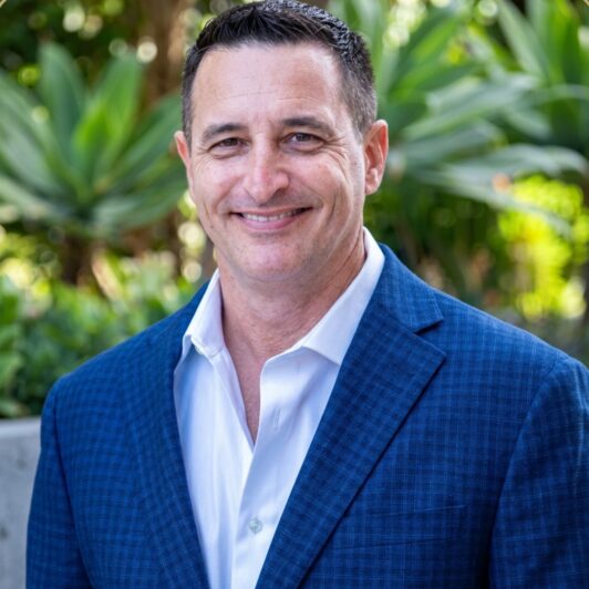 Headshot of Seth Breton in a collared, blue button down shirt and a dark blue blazer