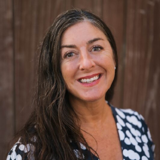 Headshot of Karla Cianci smiling in a black and white polka dot shirt