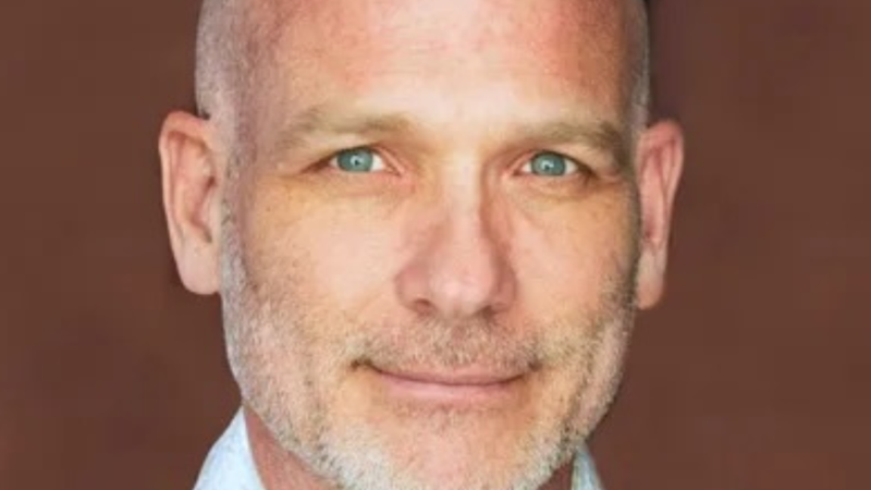 Headshot of Kevin McIntyre with black kippah, blue collared shirt, and a white talis