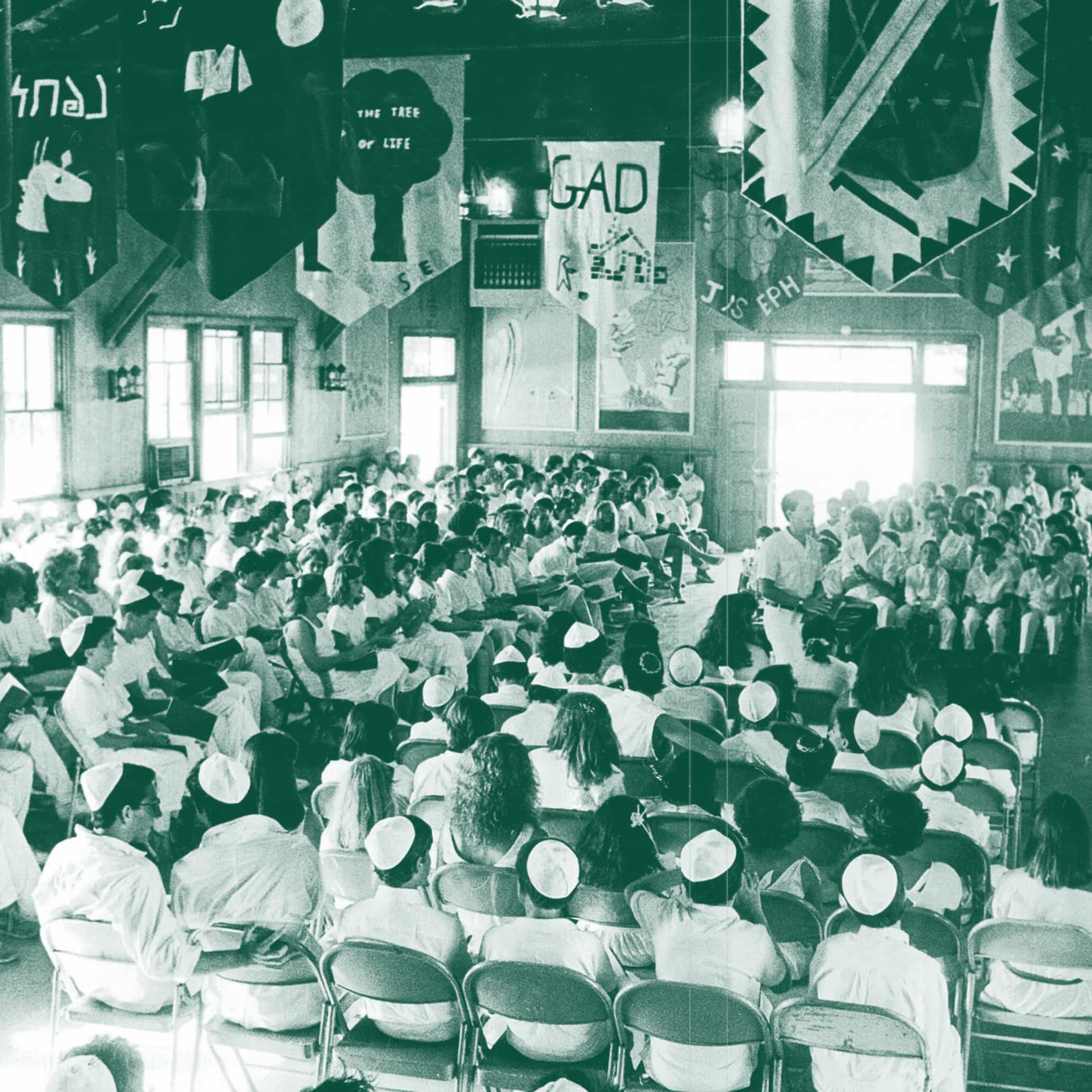 An old photo with a green-tinted overlay. It is an image of Alonim campers at an religious assembly