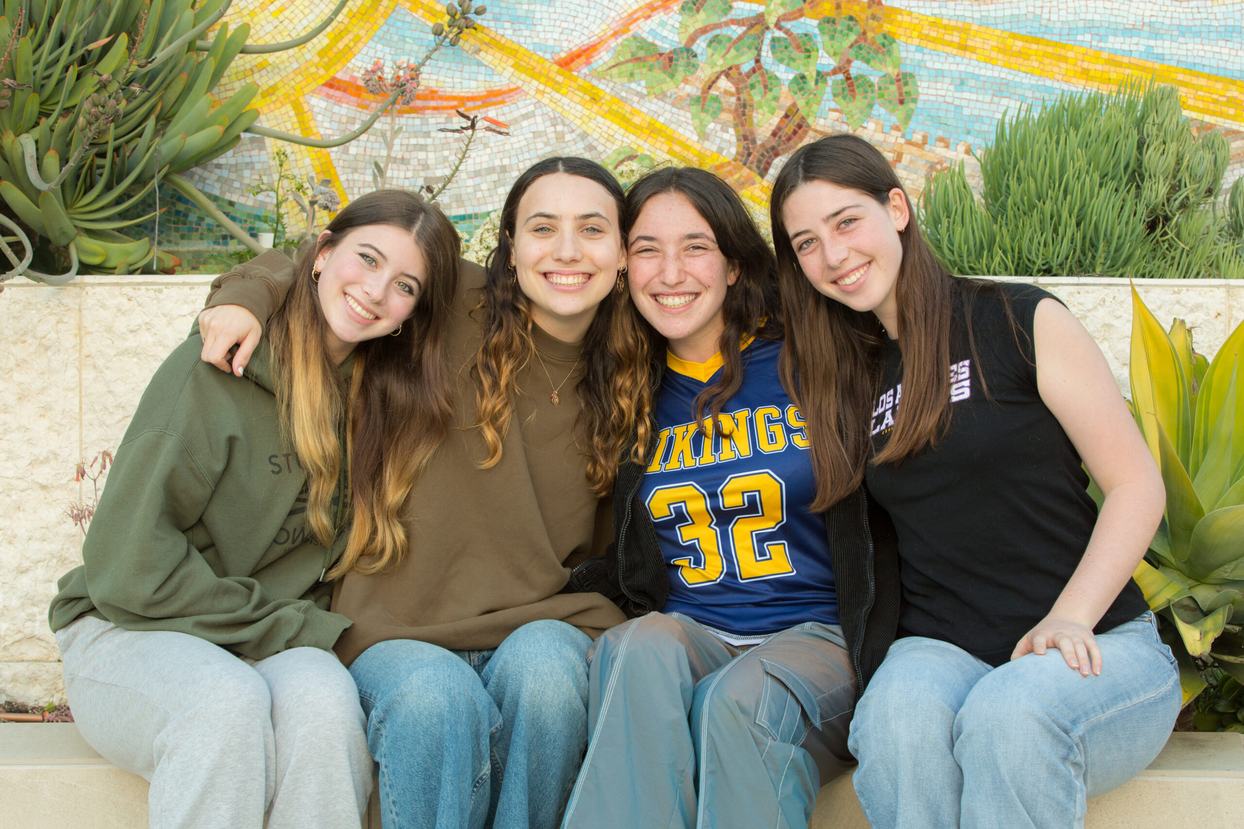 Four JLE students smiling and posing together